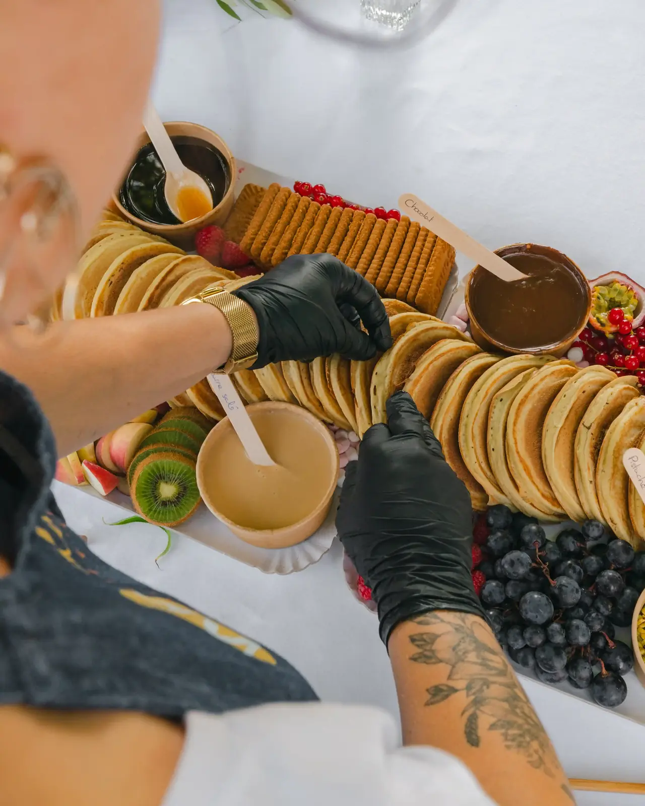 Garnissage d'un buffet de pancakes au chocolat et aux fruits