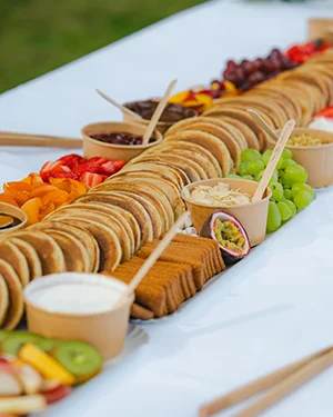 Grand buffet de pancakes garnis de fruits frais dressé en extérieur
